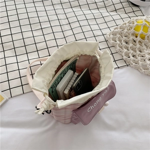 Top view of pink bucket bag capacity showing phone and books with drawstring closure