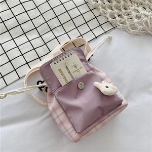 Detail of cute pink plaid crossbody bag with rabbit plush and adjustable fabric strap