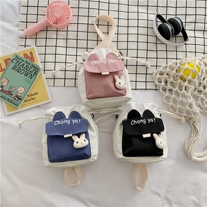 Detail of drawstring bucket bags in pink, blue, and black with 3D bunny ears