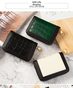 Three compact faux-leather wallets in black, dark green, and beige with crocodile texture