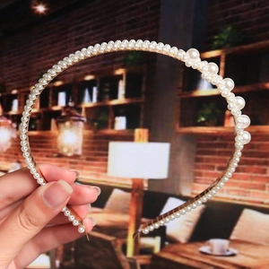 Close-up of elegant bridal headband with white faux pearls on a gold-tone wire frame