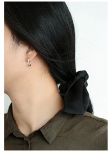 Silver U-shaped horseshoe earrings shown on model for a minimalist fashion look