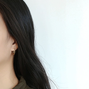 Elegant gold U-shaped horseshoe earrings shown on model with minimalist geometric design