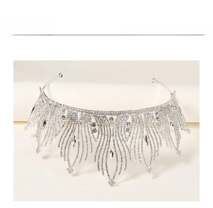 Macro view of bridal silver crown with feather patterns and water drop crystal pendants
