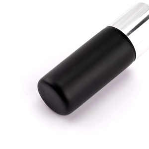 Détail du pinceau à poudre portable avec manche noir mat et capuchon en argent
