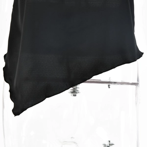 Close-up of black satin fabric showing the soft texture and irregular wavy hem detail
