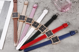 Detailed view of square starry dial watches with 7 colorful leather straps on marble