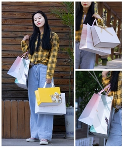 Detailed view of various paper gift bags featuring marble patterns and ribbon handles