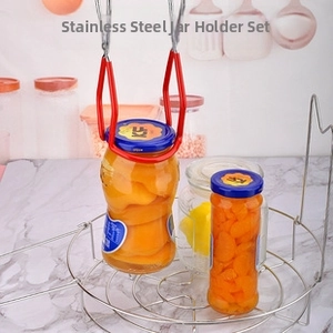Macro view of stainless steel canning jar lifter set with red non-slip handle usage