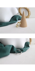Close-up of irregular wave open rings in gold and silver finish with elegant props