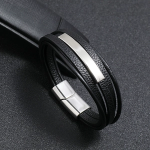 Macro shot of multi-layer black leather bracelet with silver metal plate and magnetic clasp