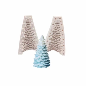 Detail of a 3D Christmas tree silicone mold with a finished light blue candle on white background