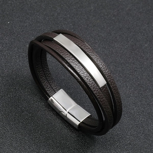 Close-up of brown braided leather bracelet with polished metal plates and magnetic clasp