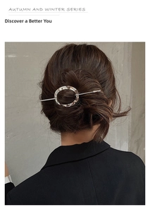 Detail of silver metal geometric hair pin with hammered texture on a brown hair bun