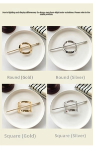 Detail of geometric hair sticks in gold and silver showing a textured metal finish