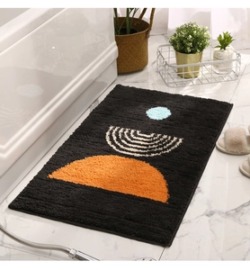 Detail view of modern plush bath mat with orange and blue abstract shapes on floor