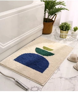 Macro detail of tufted bath mat featuring abstract blue and green shapes on marble floor