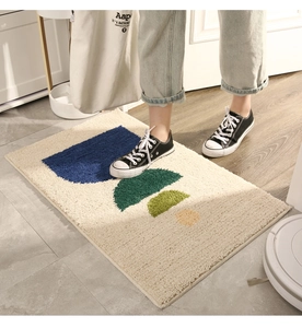 Close-up of geometric tufted doormat featuring soft beige fabric and colorful semi-circles