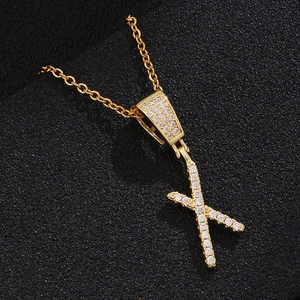 Detail of 18K gold letter X pendant with micro-pave cubic zirconia on thin link chain