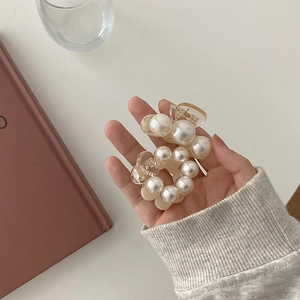 Detailed view of two elegant pearl hair clips with round and semi-circle designs