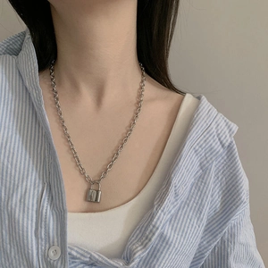 Detail of silver titanium steel chain necklace with lock pendant on a male model