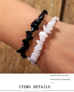Detalle de pulseras tejidas a mano con cuentas de piedras irregulares blancas y negras