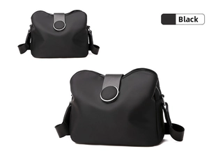 Detail of black nylon crossbody bag with round buckle and wide adjustable shoulder strap
