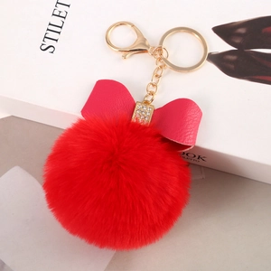 Detail of red faux rabbit fur pompom keychain with pink bow and sparkling rhinestone