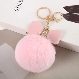 Detail of pink faux rabbit fur keychain with leather bow and sparkling crystal center