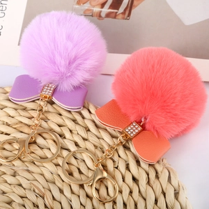 Detail of soft 8cm faux rabbit fur pom poms with rhinestone bows and gold keychains