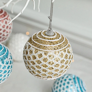Glittery gold Christmas ball ornament with white mesh pattern and hanging string