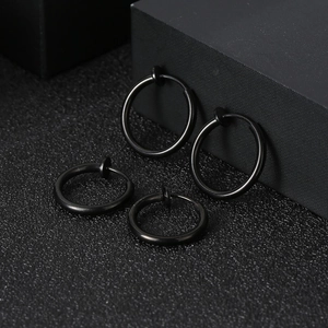 Set of four black titanium steel spring ear clips in two sizes on minimalist black display