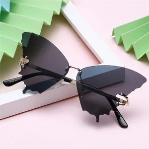 Rimless butterfly sunglasses with dark grey gradient lenses and gold metal accents