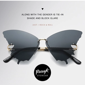 Close-up of butterfly rimless sunglasses with grey wave edge lenses and gold metal bridge