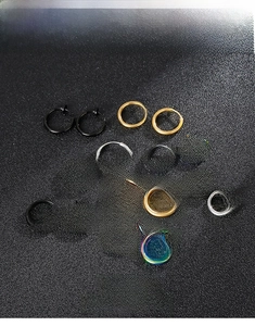 Detailed view of 14 pieces of polished stainless steel spring clip-on earrings in four colors