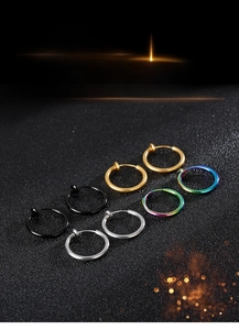 Detail view of four colorful spring-clip non-piercing earrings on black texture