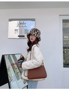 Winter-Streetstyle mit Plüsch-Anglerhut im Leopardenmuster und weißer Daunenjacke