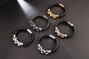 Detail view of various mens braided leather bracelets with mixed metal hexagonal rings