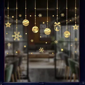 Gros plan de stickers de Noël dorés avec flocons et rennes sur une vitre en verre