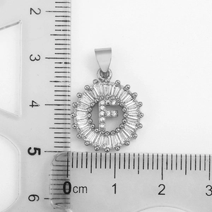 Détail du pendentif lettre F argenté avec zircons et règle pour échelle de taille
