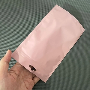 Close-up of a matte pink stand-up foil pouch with hang hole for jewelry and cables