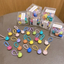 Detail of cute macaron-colored bunny hair ties in various pastel shades in a gift box