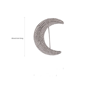 Detail view of crescent moon brooch with clear rhinestones measuring 6cm in length