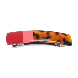 Close-up of a three-section tortoiseshell and pink acetate hair clip with silver metal spring
