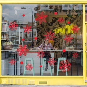 Red Christmas snowflake window stickers applied on store glass for festive decoration