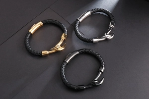 Detail of men's braided leather bracelets with gold, silver, and gunmetal hook clasps