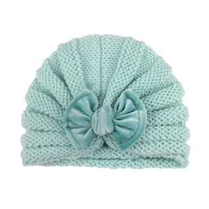 Detail of baby mint green knit beanie featuring a soft velvet bow decoration