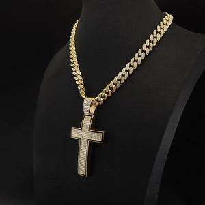 Close-up of a sparkling gold iced-out cross pendant on a thick Cuban link chain necklace