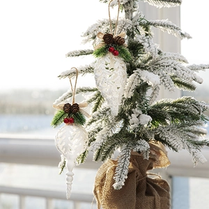 Elegant Christmas tree ornament with white cutout, pine cones, and red winter berries