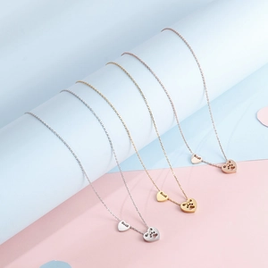 Collana con ciondolo a cuore e impronta di zampa in argento, oro e tonalità oro rosa